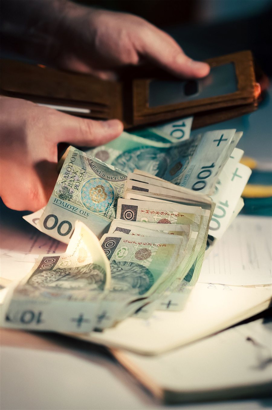 Dłonie i banknoty stuzłotowe - codzienna relacja z pieniędzmi